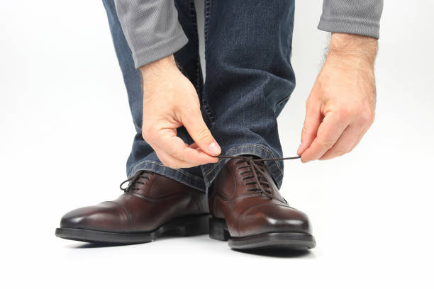 istock Man tying shoelaces on classic brown shoes 1185545435