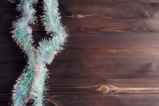 istock Decorated mock up. Light tinsel on a wooden background. Flat lay, top view 1185546286