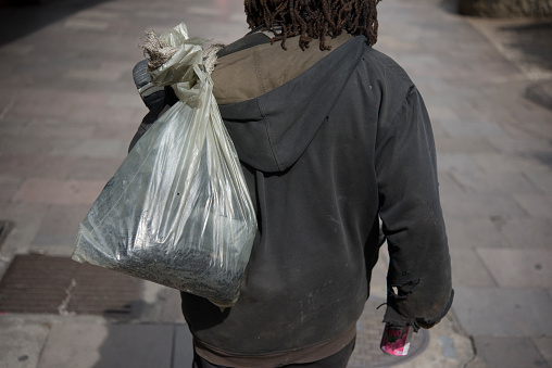 Sao Paulo, Brazil - December 21, 2015: Homeless in the streets carrying a plastic bag. The government of Sao Paulo previews that more than 25.000 (twenty thousand) people live in the city streets