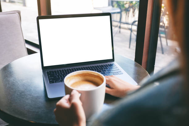 istock a woman using and typing on laptop with blank white desktop screen while drinking coffee 1185551808