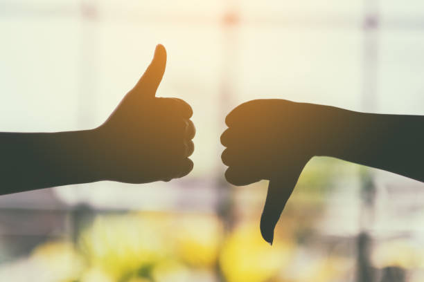 two hands making thumbs up and thumbs down sign