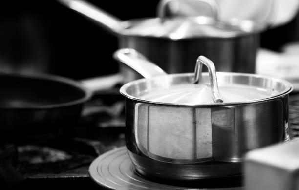 istock chef cooking in a kitchen, chef at work, Black & White background 1185561197
