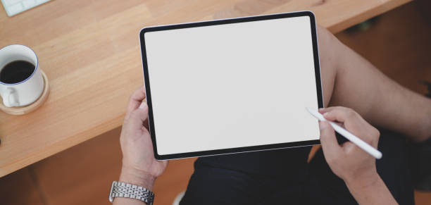istock Cropped shot of young man holding blank screen tablet in comfortable workspace 1185561224