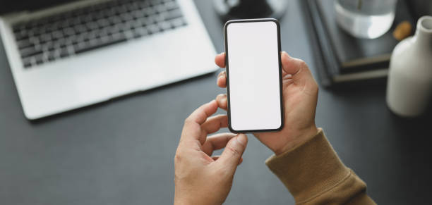 istock Cropped shot of man holding blank screen smartphone while working on his project 1185561237