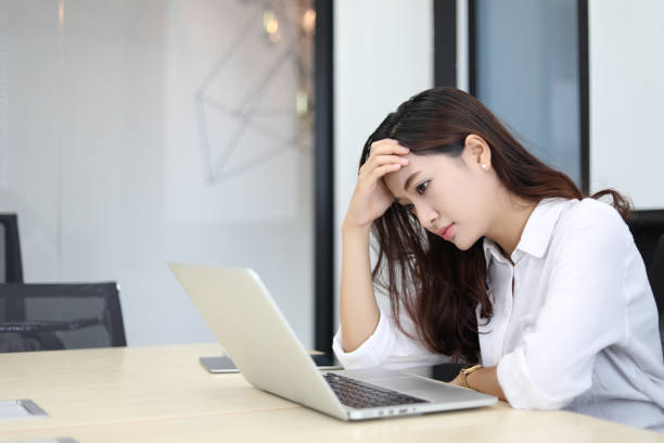 istock Asian business women using notebook and  serious and headache for working 1185562124