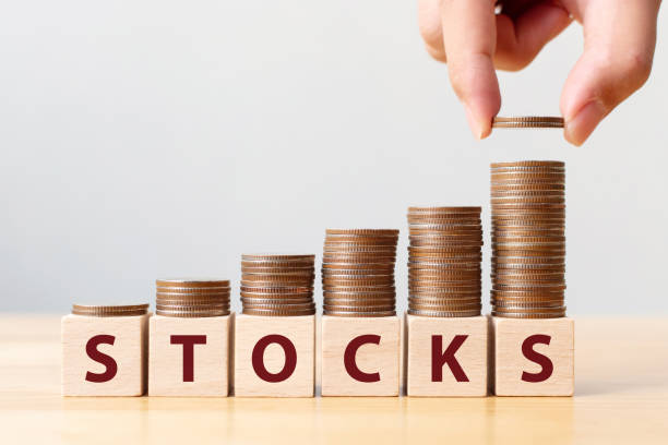 istock Hand putting coins on stack stair as step growing growth and wooden cube block with word STOCKS. Investment and save money concept 1185563959