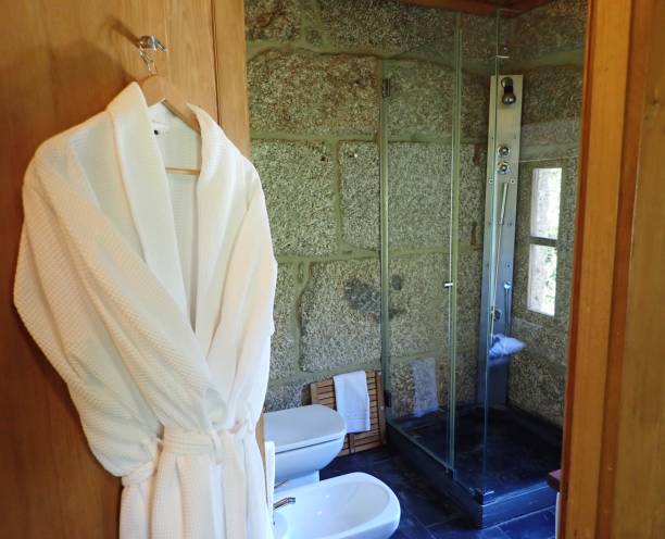 istock white bath robe and toilet and shower in bathroom 1185566558