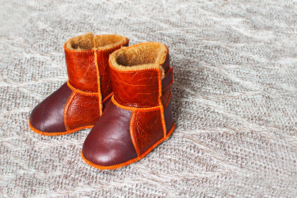 istock A pair of children's ugg boots on brown background. 1185569308