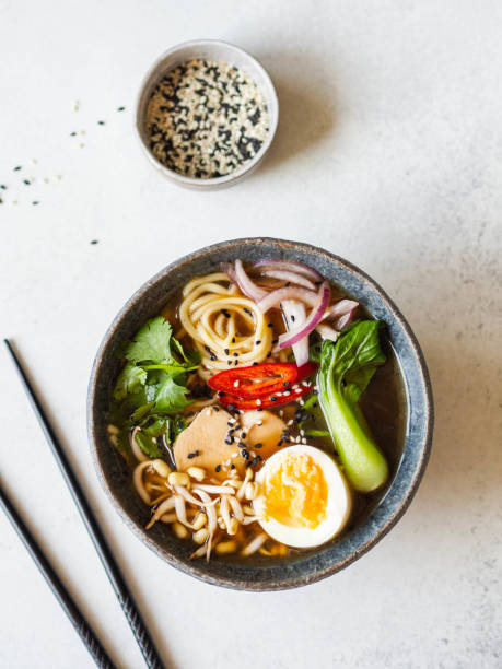 istock Asian Ramen noodles with chicken, pak choi cabbage and egg on grey background. Top view. Copy space 1185576010