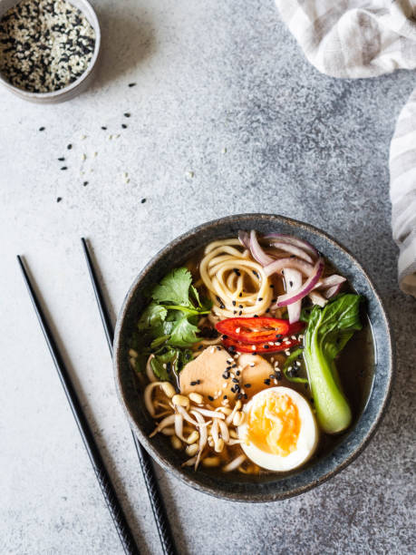 istock Asian Ramen noodles with chicken, pak choi cabbage and egg on grey background. Top view 1185576011