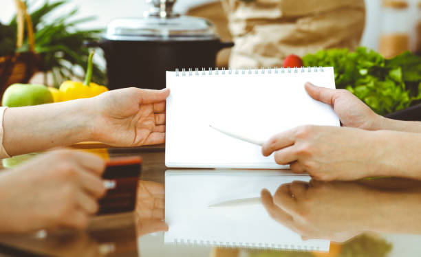 istock Closeup of human hands discussing something while cooking in kitchen. Women talking about menu. Family dinner, friendship and lifestyle concept. 1185579210