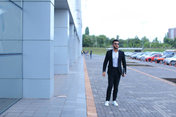 istock Arabic guy in business center stands smiling walking slow 1185579352