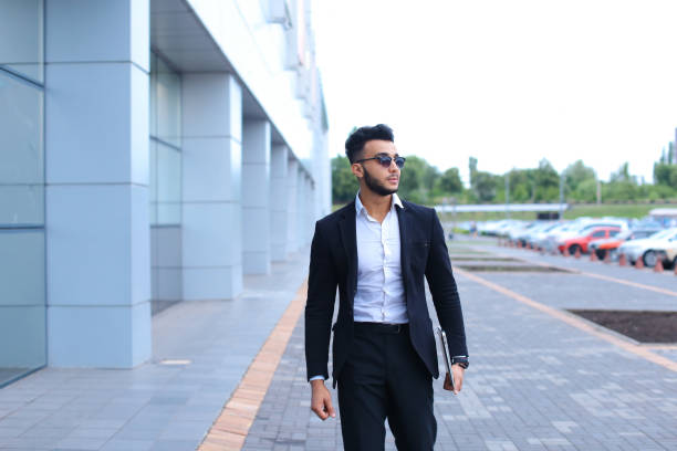 istock Arabic guy in business center stands smiling walking slow 1185579434