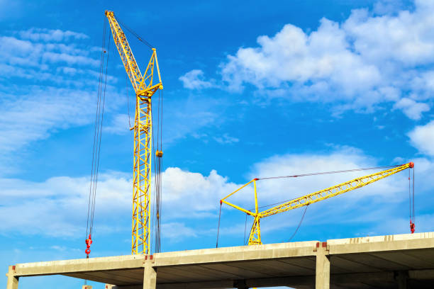 istock Construction site with two cranes and concrete structures against the sky 1185579489