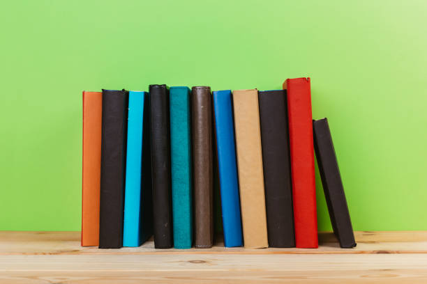 istock Simple Simple composition of many hardback books, unprocessed books on a wooden table and a green background. back to school. Copy space. Education. 1185582047