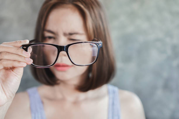 lunettes asiatiques de fixation de femme ayant le problème avec la vision de flou d'oeil - optics store photos et images de collection