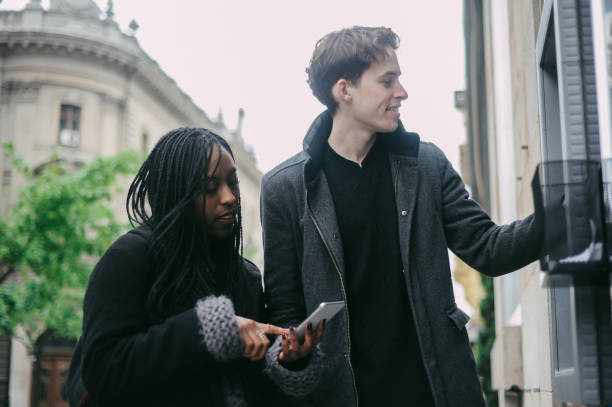 istock Diverse millennial couple, withdrawing cash at ATM 1185590650
