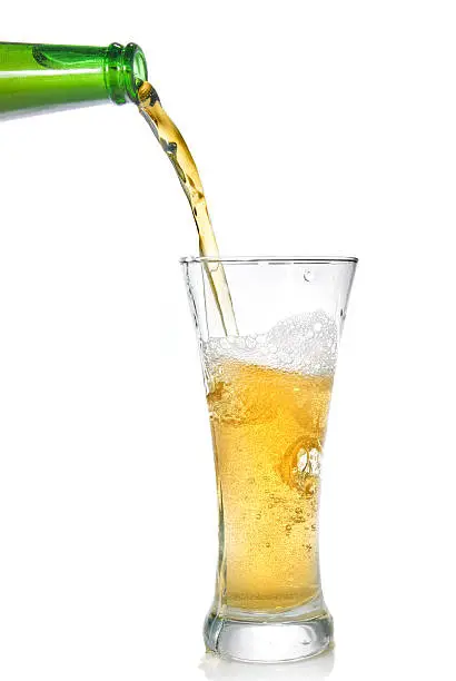 Photo of Beer pouring from bottle into glass