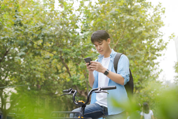 istock man with smart phone and bicycle on street 1185593479