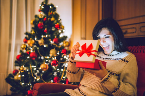istock Woman opening wrapped Christmas gift 1185593583