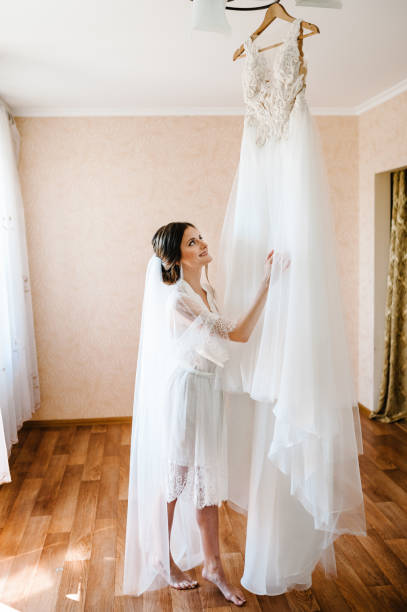 istock Bride touch on white wedding dress. Bride. Preparations. 1185593929