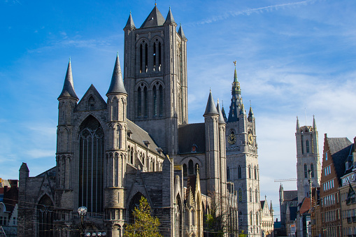 Facade of Saint Nicholas' Church (Sint-Niklaaskerk) with the clock tower of Belfry of Ghent (Het Belfort) and Saint Bavo Cathedral (Sint-Baafskathedraal) at the background, in Ghent, Belgium. Typical picture from Ghent