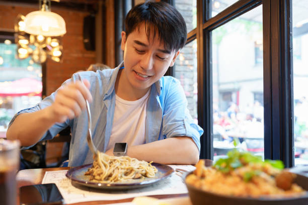 istock young asian man eating noodle 1185594050