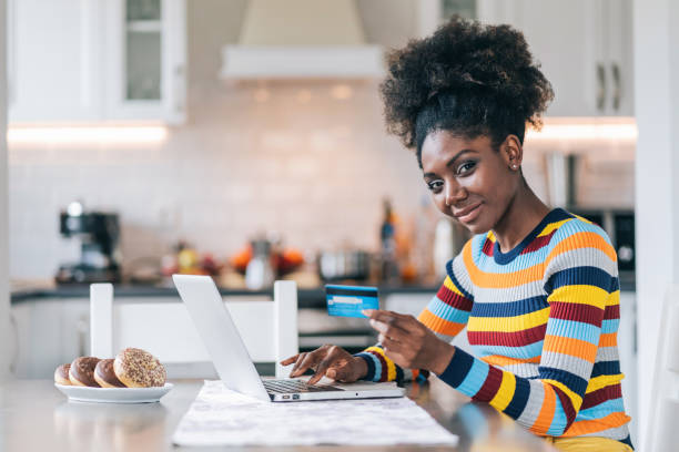 istock Smiling afro woman shopping online at home 1185596830