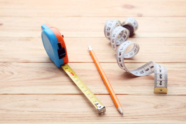 istock Construction roulette with pencil and measuring tape on brown wooden table 1185596834