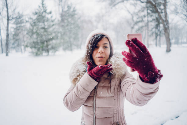 istock Woman taking selfies in the snow 1185599052