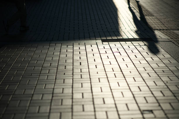 istock Shadow of pedestrian on tile pavement in Tokyo 1185604176