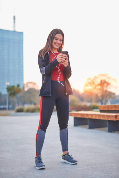 istock Modern young woman with cellphone making pause during jogging / exercise. 1185609241