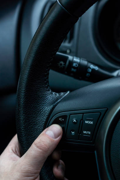 istock Hand of driver on steering wheel adjusts audio volume control 1185609726