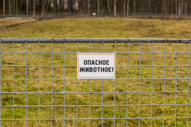 schild auf zaun von leeren outdoor-corral berichte von gefährlichen tier - animal captivity building stock-fotos und bilder