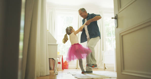 おじいちゃんは彼女をロイヤリティのように感じさせる方法を知っている - grandparent with child grandchild ストックフォトと画像