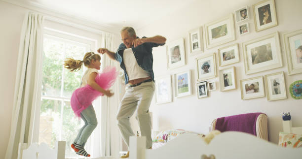 Your parents just left, let the fun begin! Shot of a senior man having fun with his granddaughter at home royal person stock pictures, royalty-free photos & images