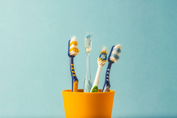 istock Many toothbrushes in a plastic cup on a blue background. The concept of changing toothbrushes, oral hygiene, dentistry. Big and friendly family. 1185612913