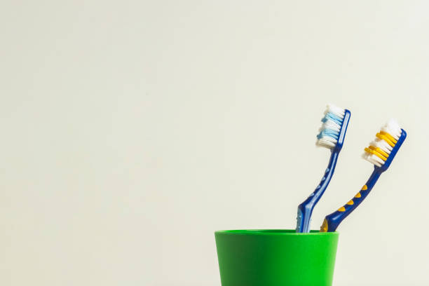 istock Two used toothbrushes in a plastic cup on a white background. The concept of changing toothbrushes, oral hygiene, dentistry, friendly family. 1185613495