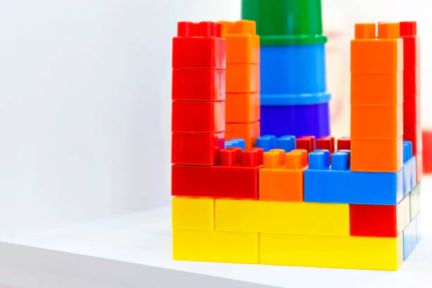 istock Toys for kids. Bright plastic building blocks educational cubes constructor and children's pyramid for games for preschoolers on a white shelf in the closet 1185613902