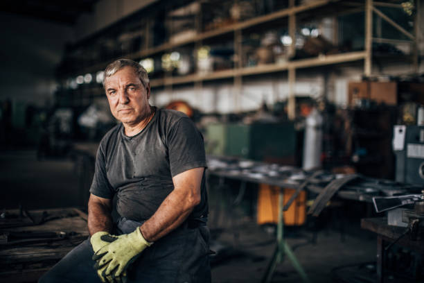 reifer mann allein in der fabrikwerkstatt - industriearbeiter stock-fotos und bilder