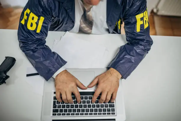 A senior FBI agent uses a laptop in the office