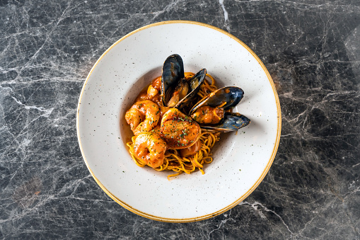 Plate of black spaghetti with prawn, mussels. Healthy food concept.