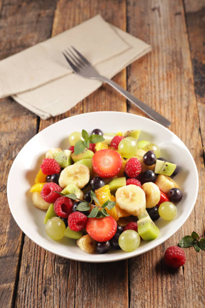 istock fresh fruit salad on wood background 1185622589