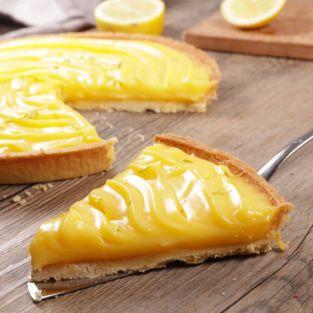 레몬 파이와 나무 배경에 슬라이스 - lemon meringue pie pie pastry crust portion 뉴스 사진 이미지