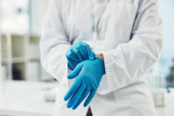 Time to dig in to another investigation Closeup shot of scientist putting on protective gloves in a lab plastic gloves stock pictures, royalty-free photos & images