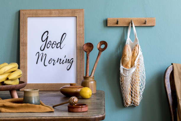 istock Vintage kitchen interior with wooden table, bag with bagles, eggs, cup of tea and kitchen accessories. Minimalistic concept of kitchen space. Country side mood. Template. Mock up picture frame. 1185627556