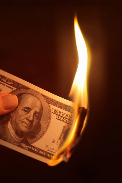 istock Hand holds burning American hundred-dollar banknote 1185629840