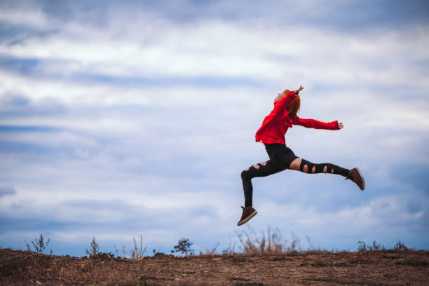 istock Jump of joy in a park 1185631529