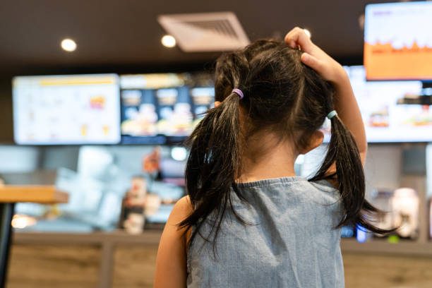 Little girl chooses fast food Little girl chooses fast food chinese ethnicity china restaurant eating stock pictures, royalty-free photos & images