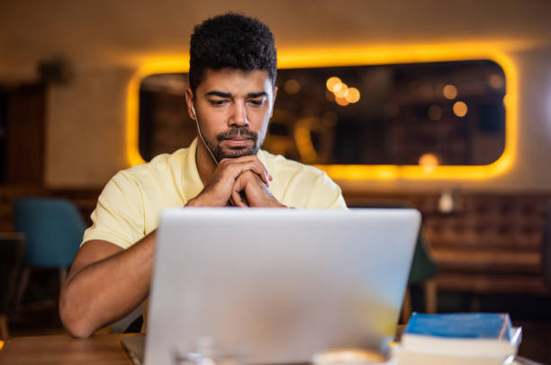 istock Serious man watching a podcast in coffee shop. 1185640513